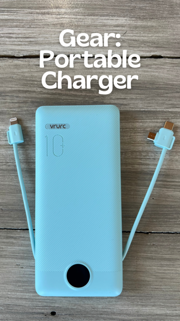 A mint green portable charger against a greay wood background with text saying: Gear: Portable Charger